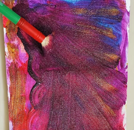 Glittery Paint used in psychotherapy sessions in individual therapy, couples therapy, family therapy and child therapy. A colourful photo showing a snapshot of the process of a painting that is being created in glitter paint also showing the paintbrush being used.